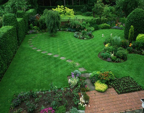 ca. 1960-1994, Hexham, Northumberland, England, UK --- Stepping stones lead from a brick terrace to green lawns.  Planned by David Stevens, this 75 x 60 feet garden, formerly a lawn tennis court, includes a brick terrace to join house and garden together. --- Image by © Michael Boys/CORBIS